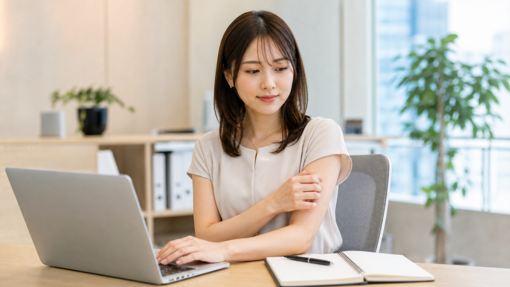 二の腕脂肪吸引後の仕事復帰について考えながらオフィスで働く女性