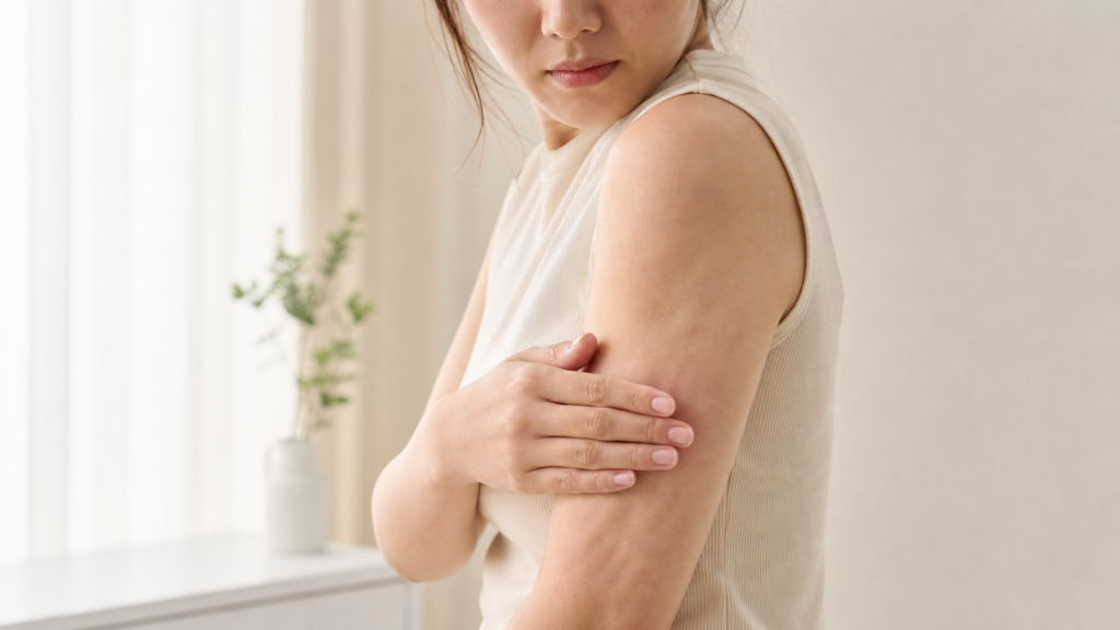 脂肪吸引後の二の腕に凹凸がないか手で触れて確認する女性